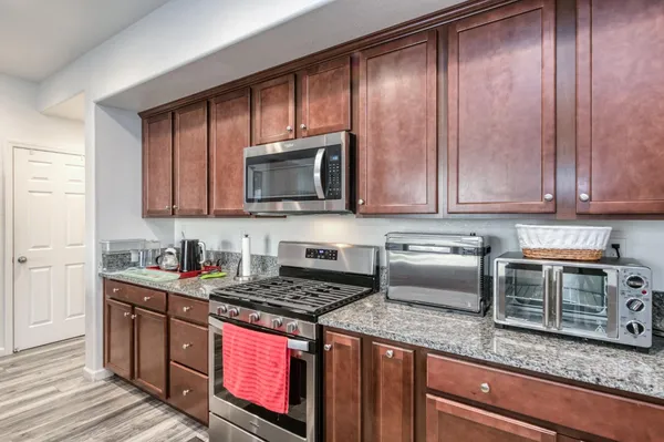 a kitchen with stainless steel appliances granite countertop wooden cabinets a stove top oven with granite countertops and cabinets