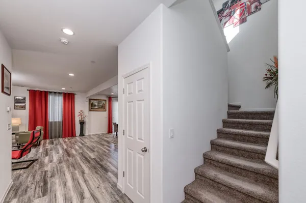 a view of a hallway with wooden floor and windows