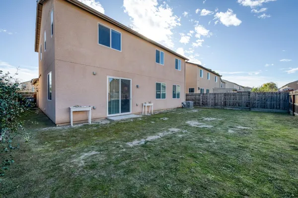a view of a house with backyard and a tree