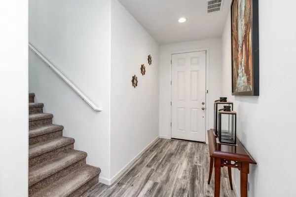 a view of a hallway with wooden floor and staircase