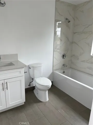 a bathroom with a toilet a sink a mirror and bathtub