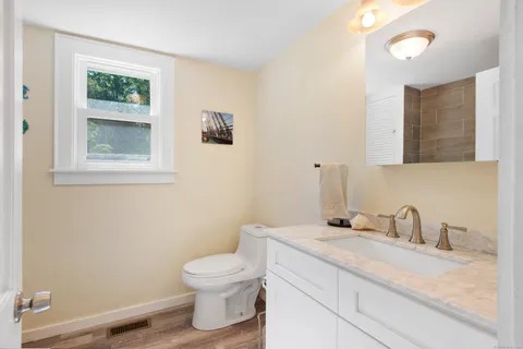 a bathroom with a granite countertop toilet and a sink