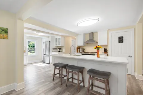 a kitchen with a table chairs refrigerator and cabinets