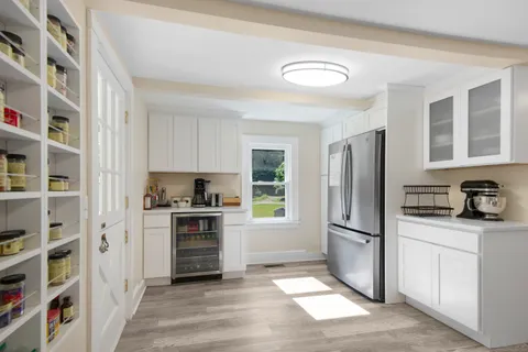 a kitchen with granite countertop a refrigerator and a stove top oven