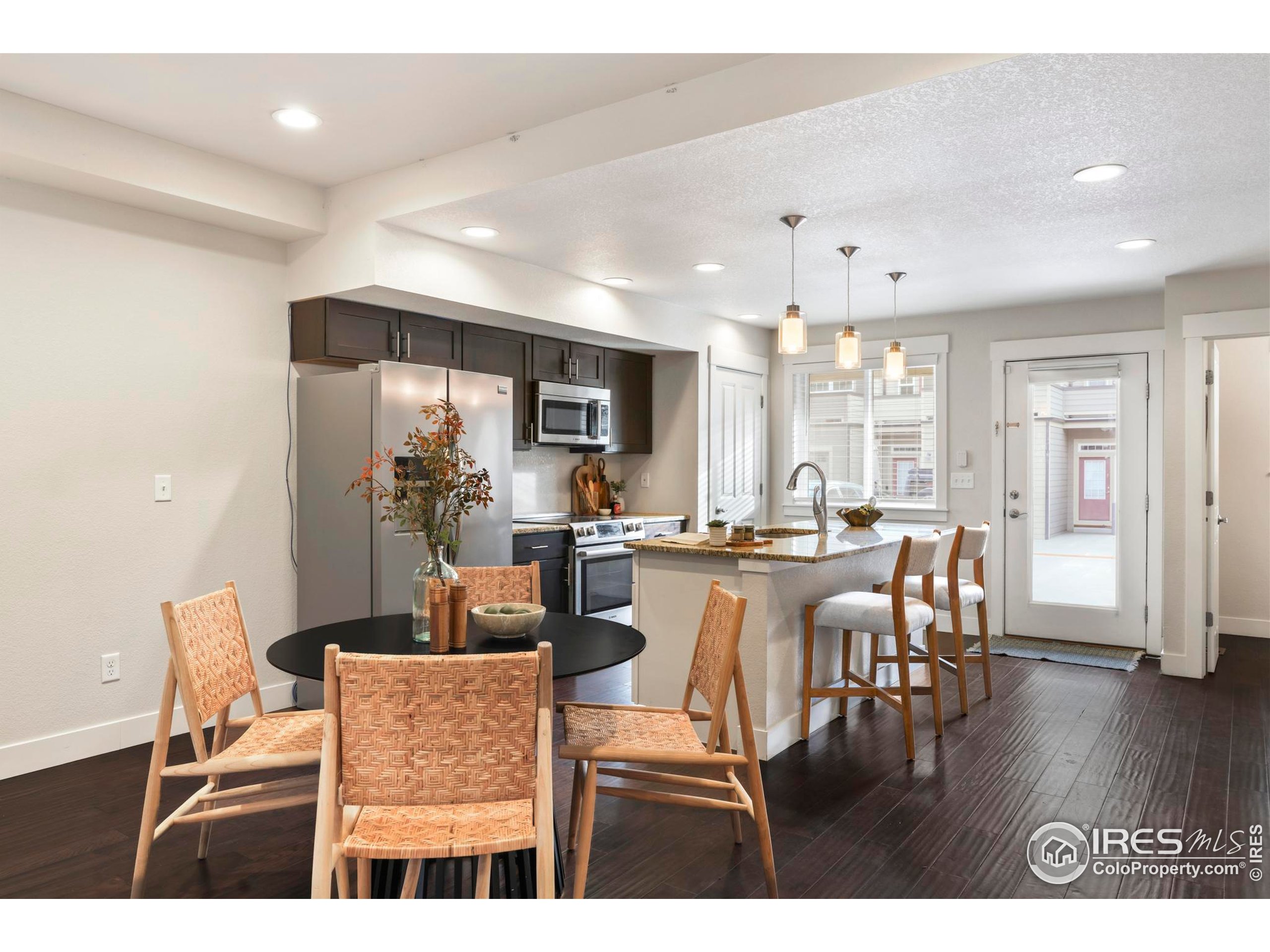 409 Terry Street, Unit B Longmont, CO 80501 - Photo 6 of 31 a view of a dining room and livingroom with furniture wooden floor a rug a fireplace
