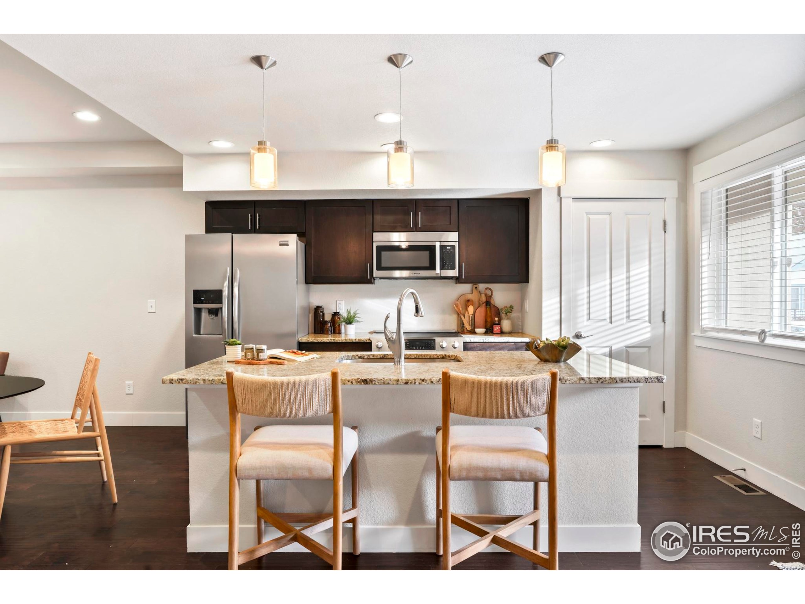 409 Terry Street, Unit B Longmont, CO 80501 - Photo 8 of 31 a kitchen with a dining table chairs and a refrigerator