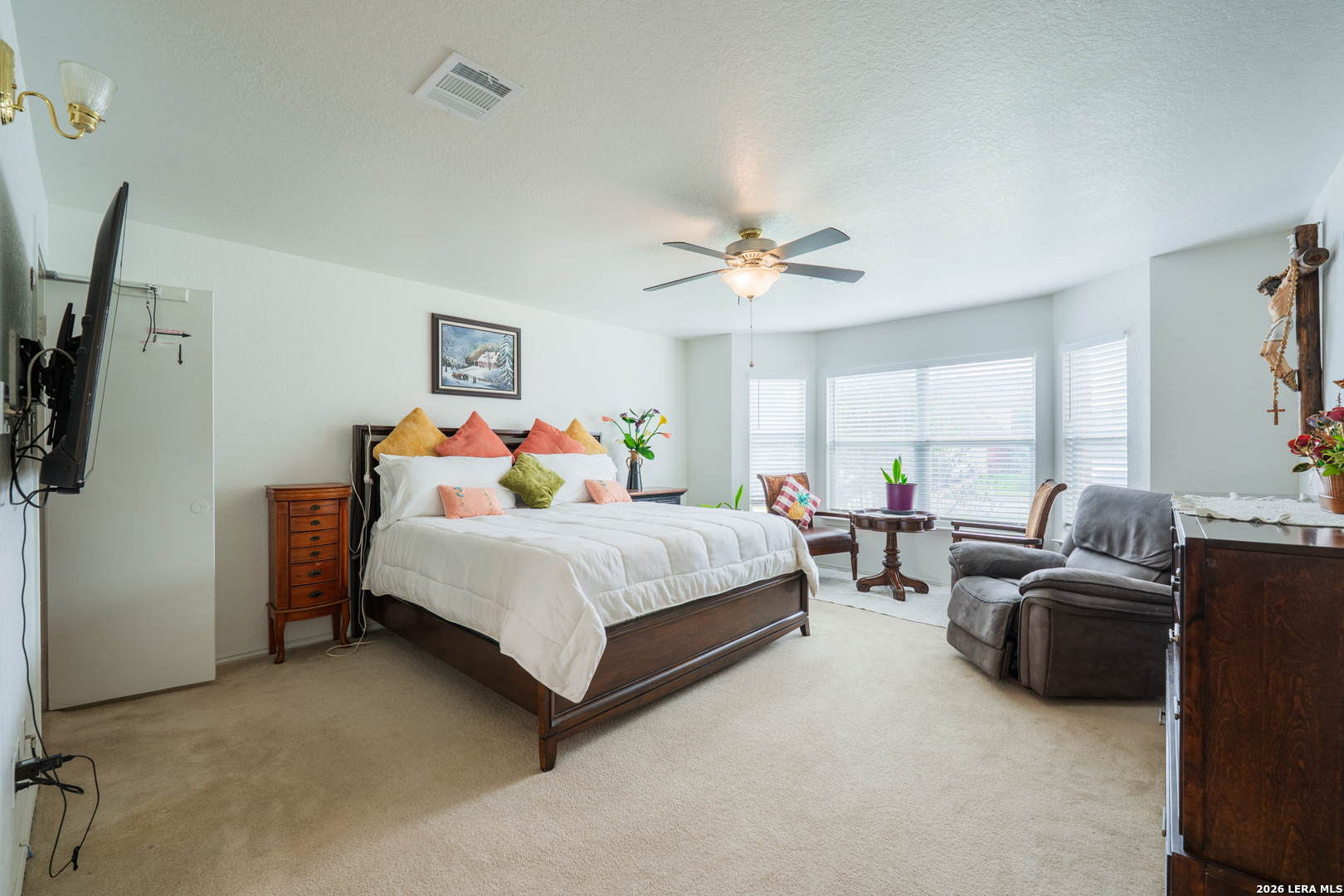 124 Springtree Grove Cibolo, TX 78108 - Photo 16 of 52 a bedroom with a bed a couch and a flat tv screen on the dresser
