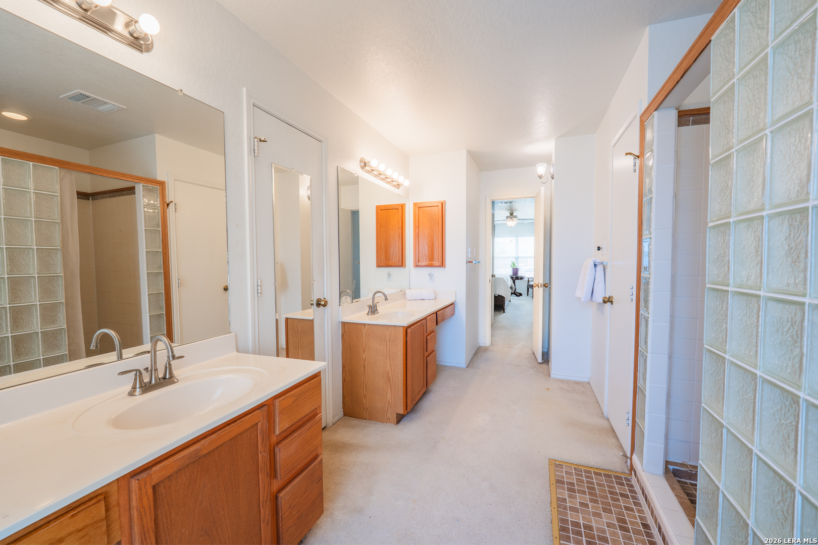 124 Springtree Grove Cibolo, TX 78108 - Photo 19 of 52 a bathroom with a double vanity sink a mirror a bathtub and shower