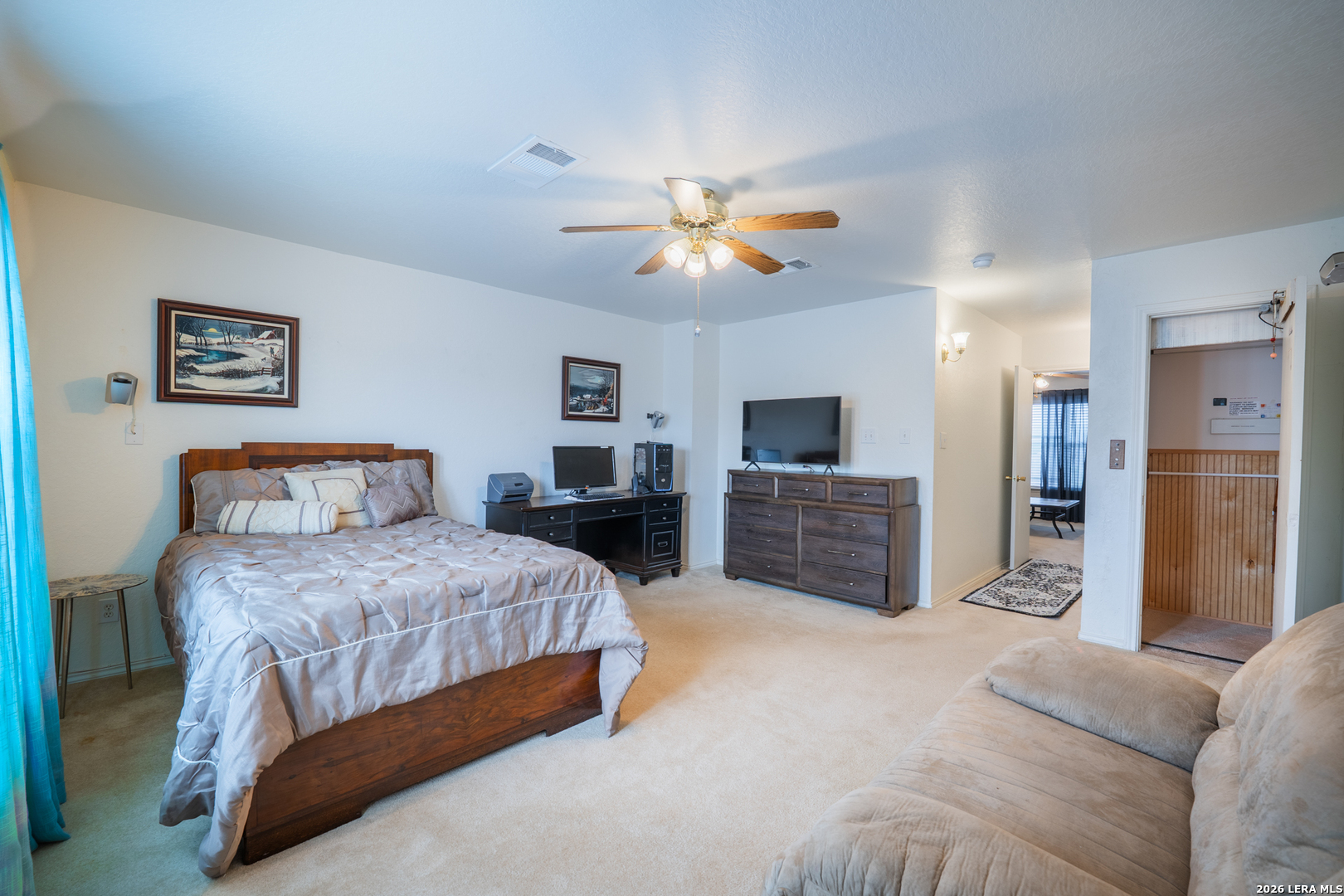 124 Springtree Grove Cibolo, TX 78108 - Photo 27 of 52 a spacious bedroom with a bed a dresser and a flat screen tv