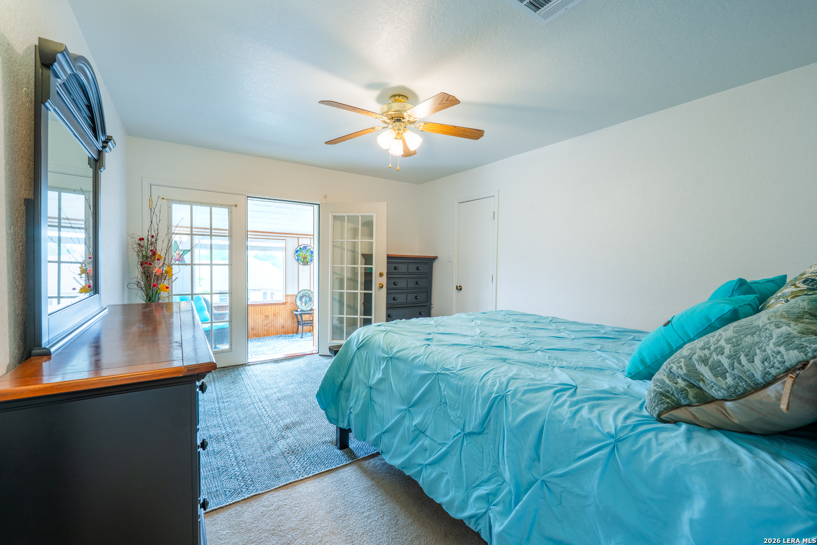 124 Springtree Grove Cibolo, TX 78108 - Photo 31 of 52 a bedroom with a large bed and a chandelier