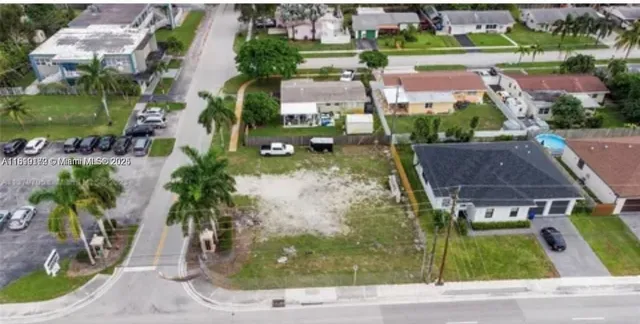 an aerial view of residential houses with outdoor space and parking