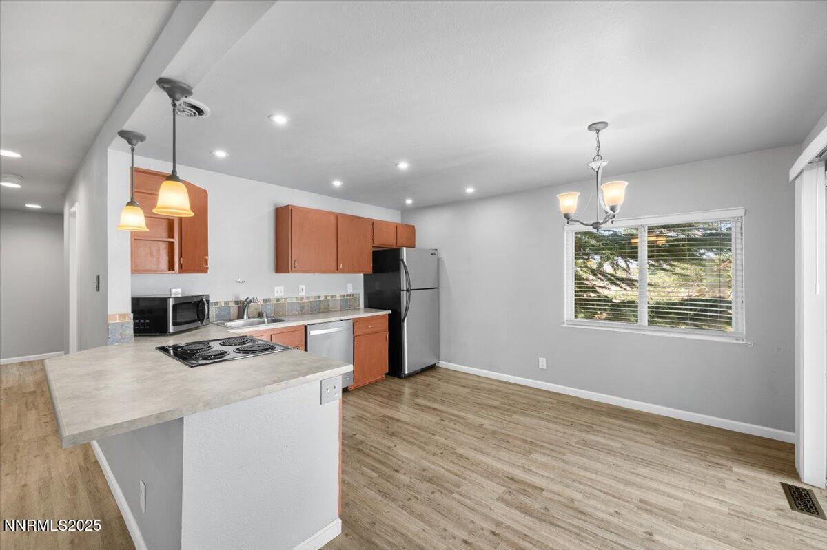 3080 Slater Avenue Reno, NV 89503 - Photo 5 of 17 a kitchen with stainless steel appliances kitchen island granite countertop a refrigerator a stove top oven a sink dishwasher and white cabinets with wooden floor