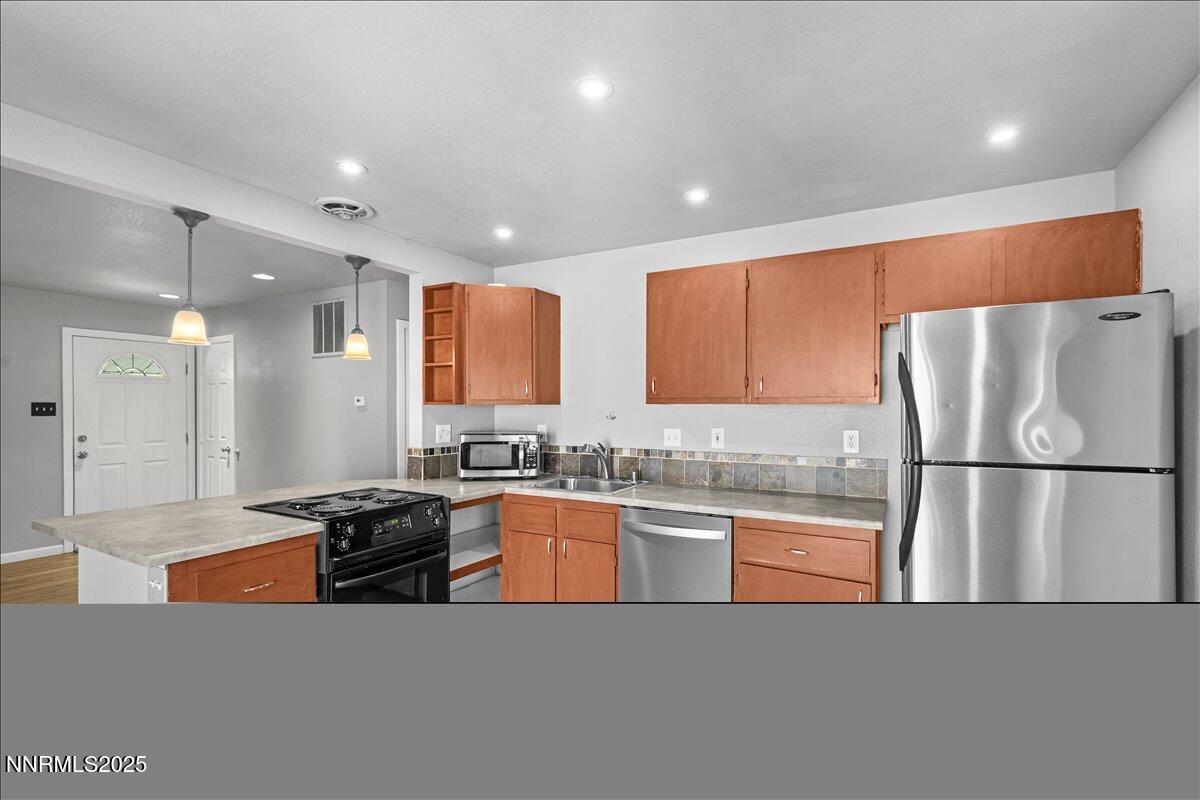 3080 Slater Avenue Reno, NV 89503 - Photo 6 of 17 a kitchen with stainless steel appliances granite countertop a refrigerator a stove a sink a oven and white cabinets with wooden floor