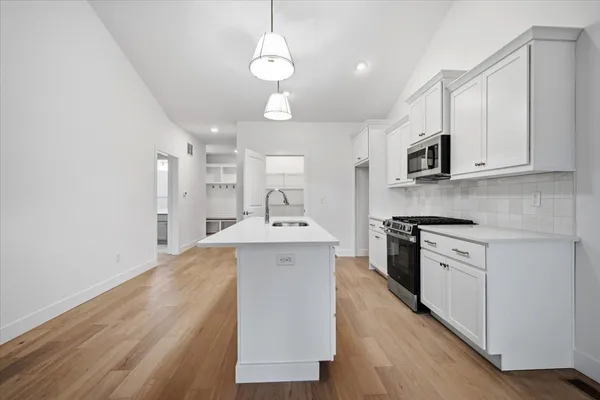 an empty room with windows and fireplace