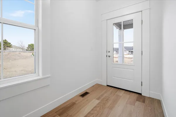an empty room with windows and mirror