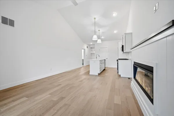 a kitchen that has a sink a stove and wooden floor