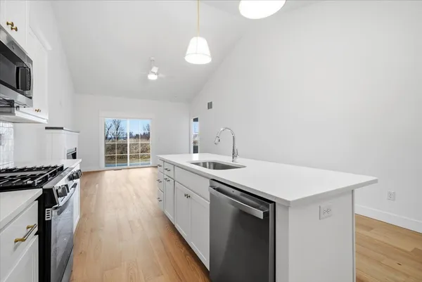 a kitchen with stainless steel appliances granite countertop a sink a stove and a refrigerator