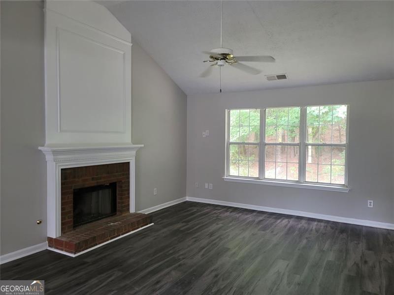 3014 Stirrup Lane Southwest Marietta, GA 30064 - Photo 3 of 10 a view of an empty room with wooden floor fireplace and a window