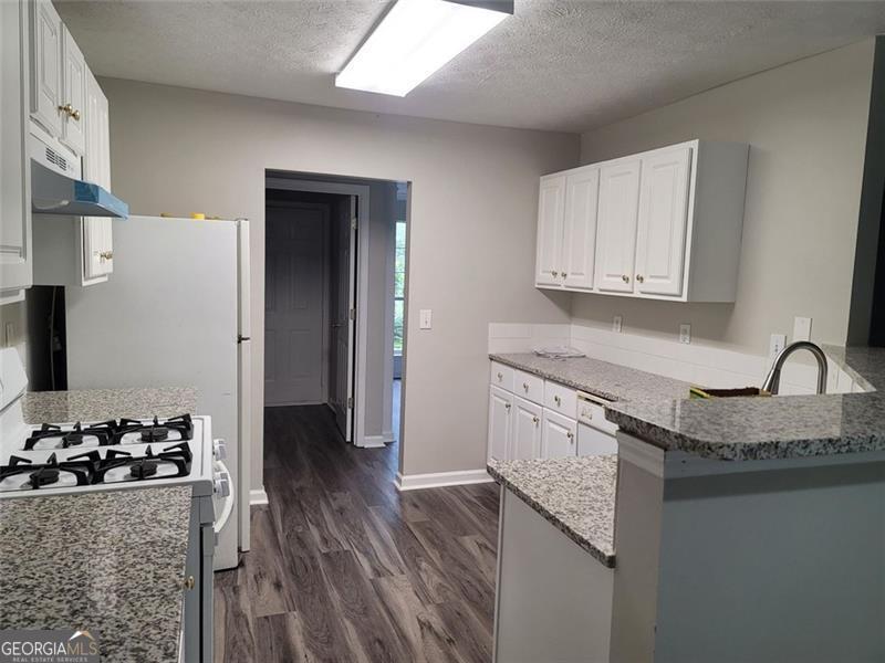 3014 Stirrup Lane Southwest Marietta, GA 30064 - Photo 4 of 10 a kitchen with stainless steel appliances granite countertop a sink stove and refrigerator