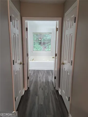 a view of a hallway with wooden floor and staircase