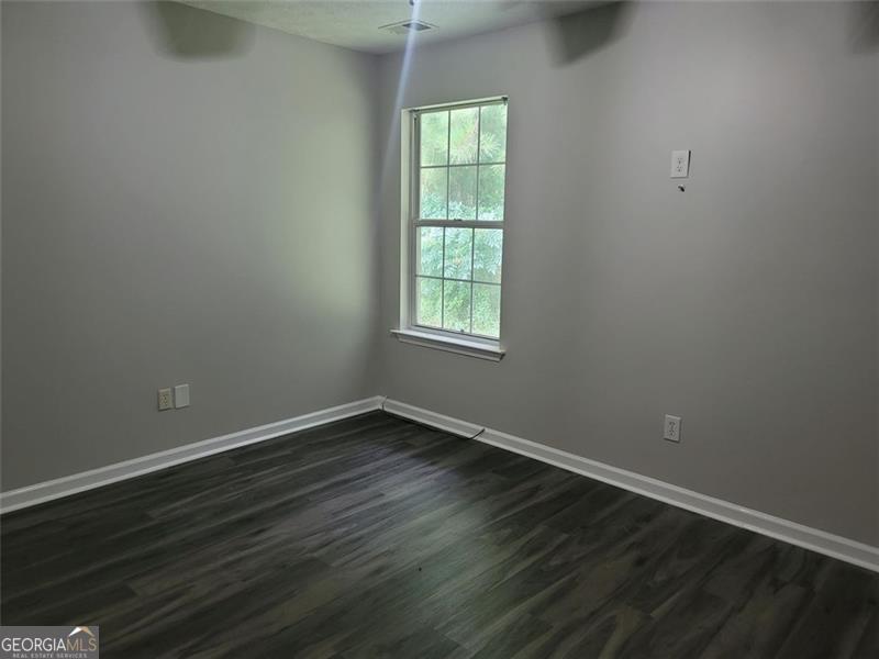3014 Stirrup Lane Southwest Marietta, GA 30064 - Photo 9 of 10 an empty room with wooden floor and windows