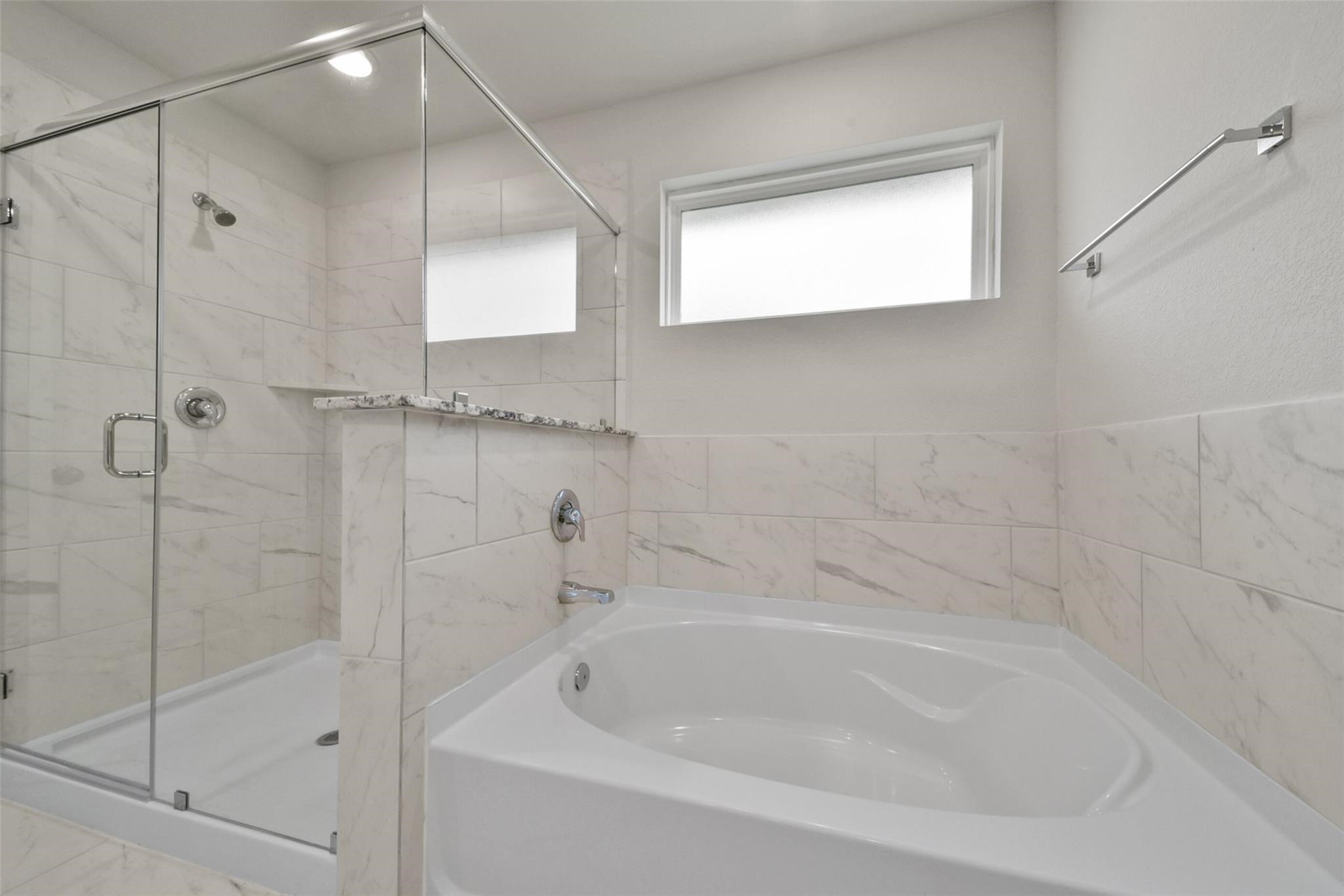 10522 Plumas Run Drive Rosharon, TX 77583 - Photo 20 of 29 Luxurious primary en-suite featuring a glass-enclosed shower, soaking tub, and elegant marble tile.