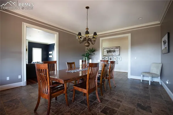 a dining room with furniture a chandelier and wooden floor