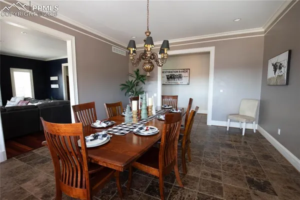 a dining room with furniture a chandelier and window