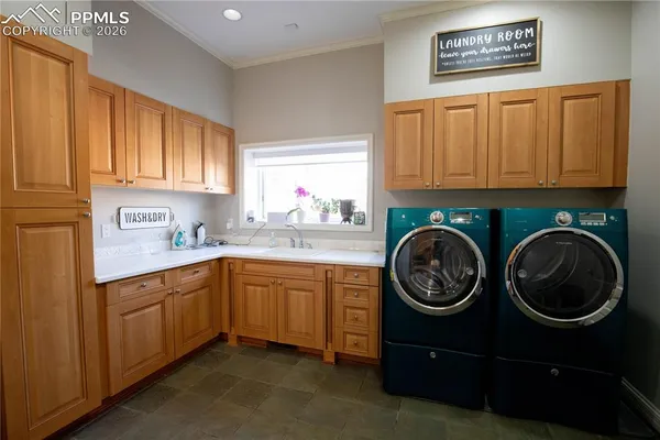 a utility room with sink cabinets and washer