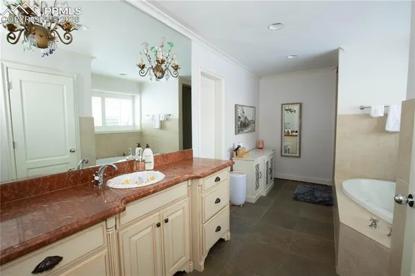 a spacious bathroom with a granite countertop sink and a mirror