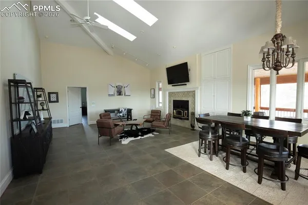 a living room with furniture a dining table and a fireplace