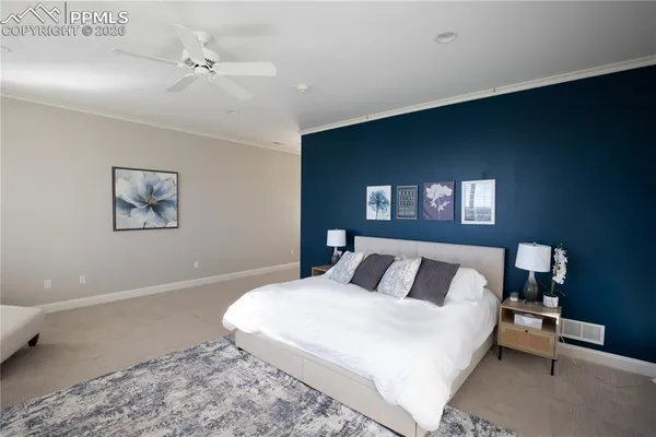 a bedroom with a bed and a lamp on dresser