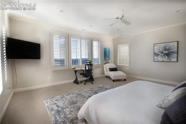 a spacious bedroom with a bed and a flat screen tv