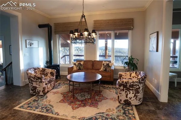 a dining room with furniture a chandelier and window