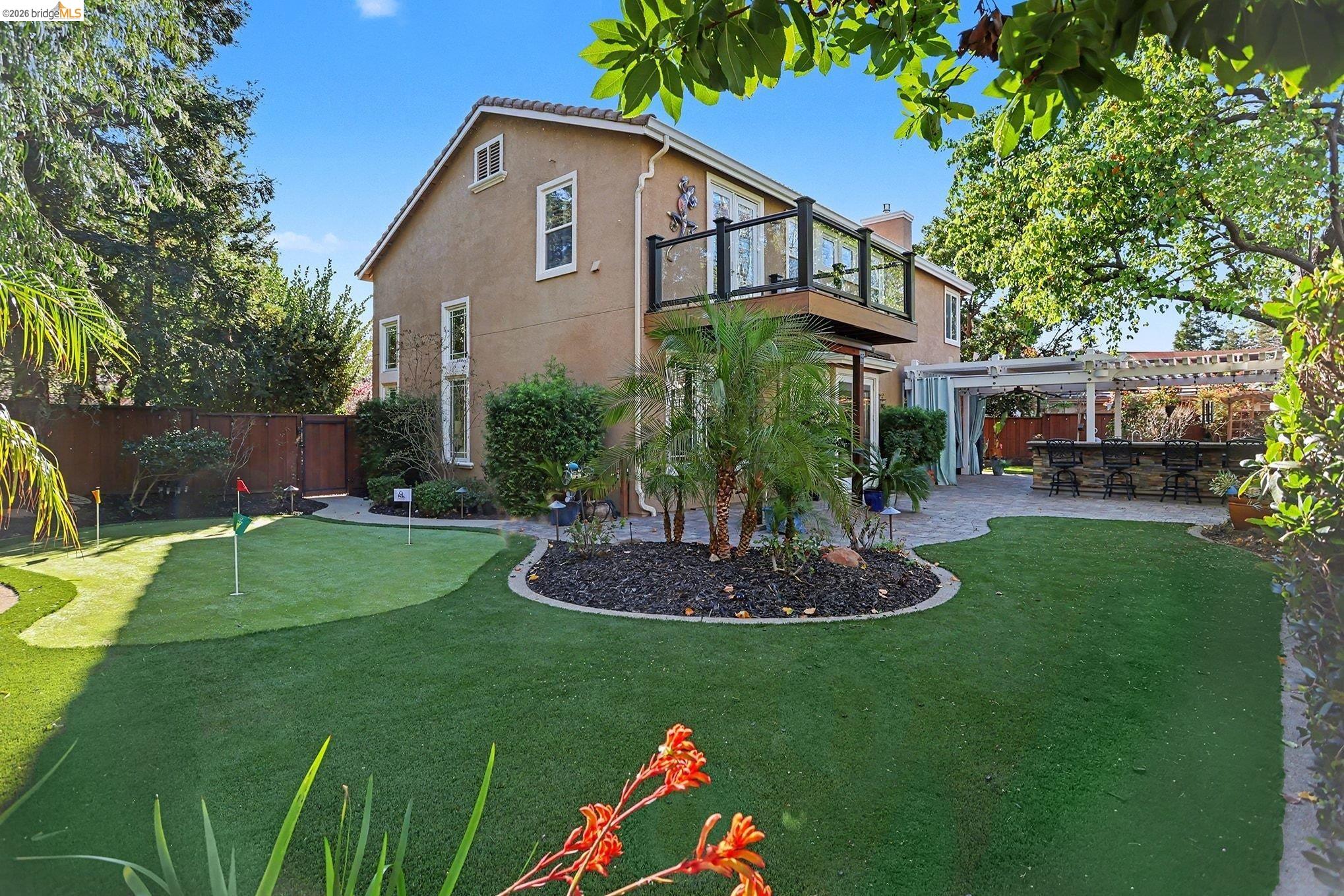 550 Rutherford Circle Brentwood, CA 94513 - Photo 18 of 28 Back of property featuring a patio, a fenced backyard, stucco siding, a putting green, and a pergola