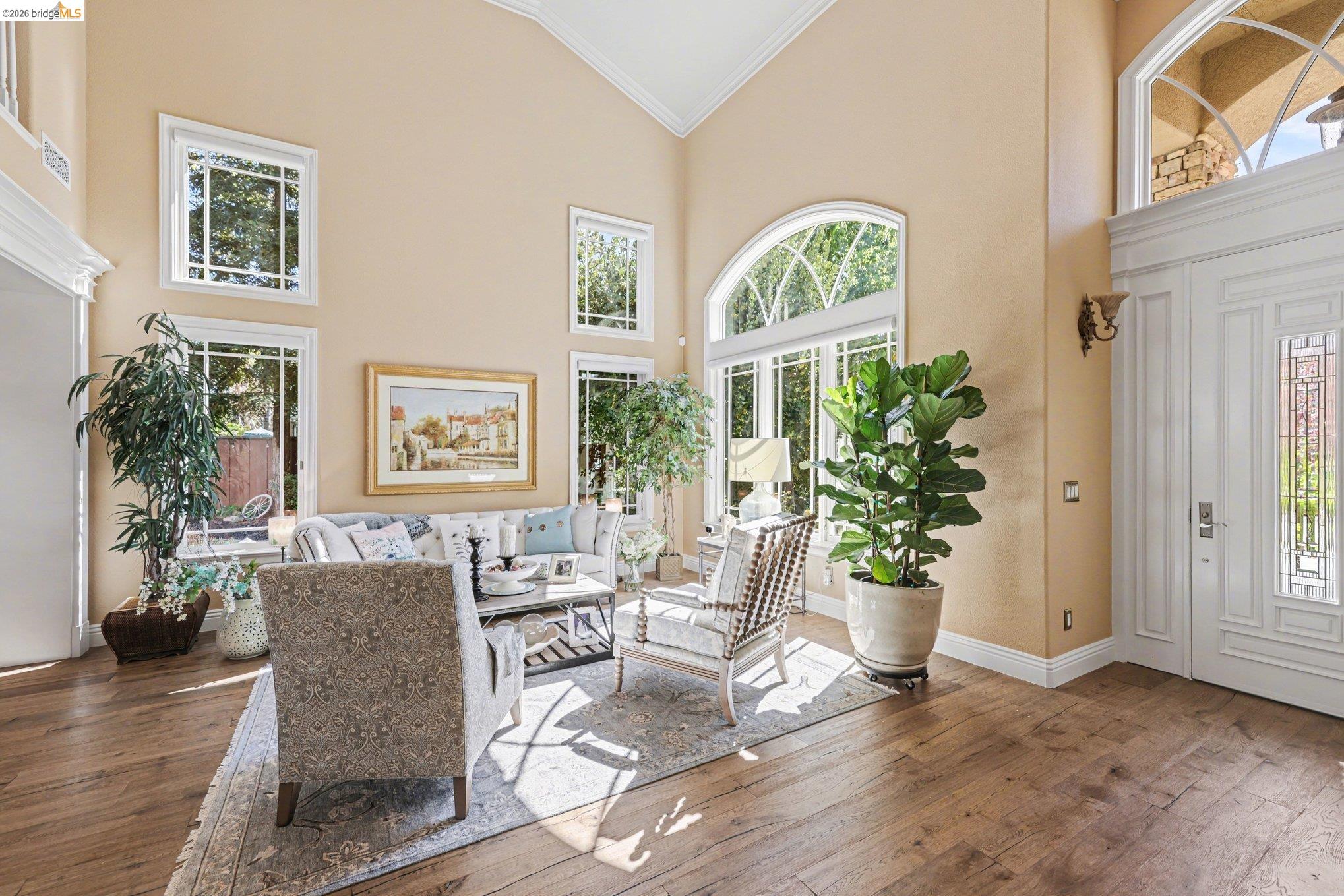 550 Rutherford Circle Brentwood, CA 94513 - Photo 5 of 28 Living room featuring hardwood / wood-style floors, crown molding, healthy amount of natural light, and lofted ceiling