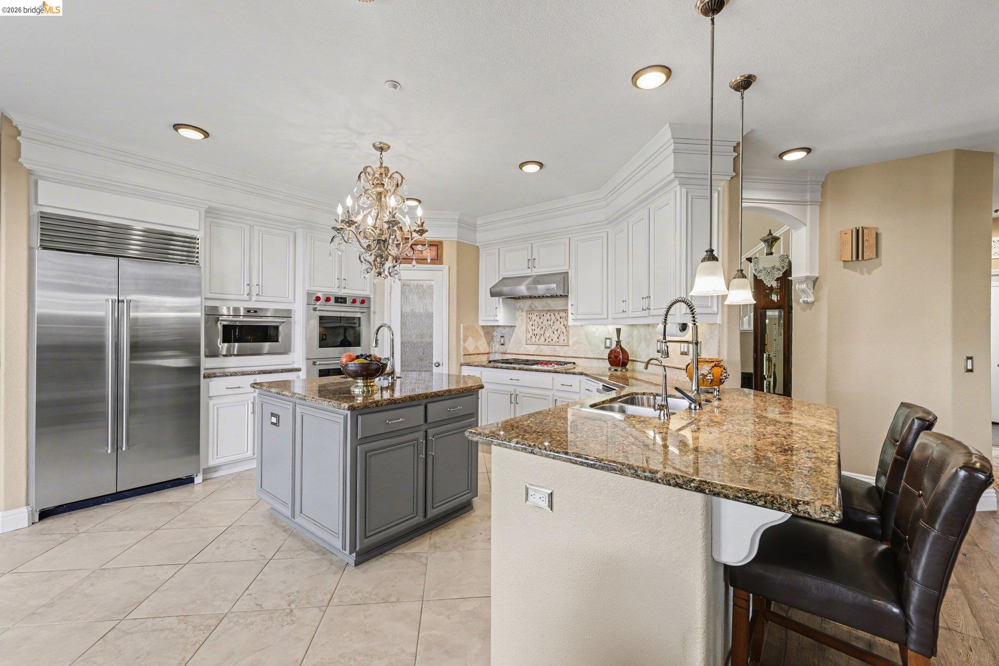 550 Rutherford Circle Brentwood, CA 94513 - Photo 8 of 28 Kitchen featuring dark stone counters, a kitchen bar, two tone color scheme, stainless steel appliances, and a peninsula