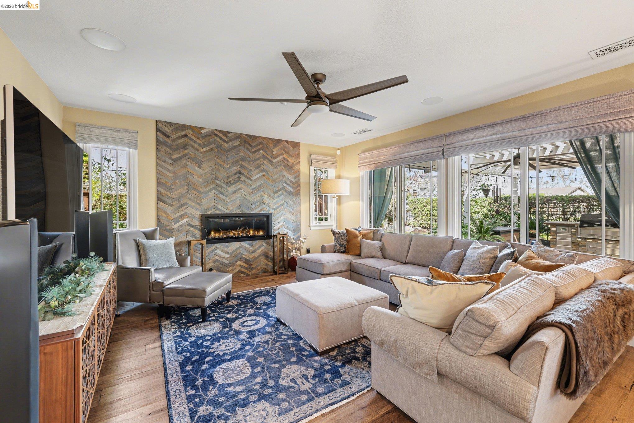 550 Rutherford Circle Brentwood, CA 94513 - Photo 9 of 28 Living room featuring a ceiling fan, wood finished floors, and a tiled fireplace