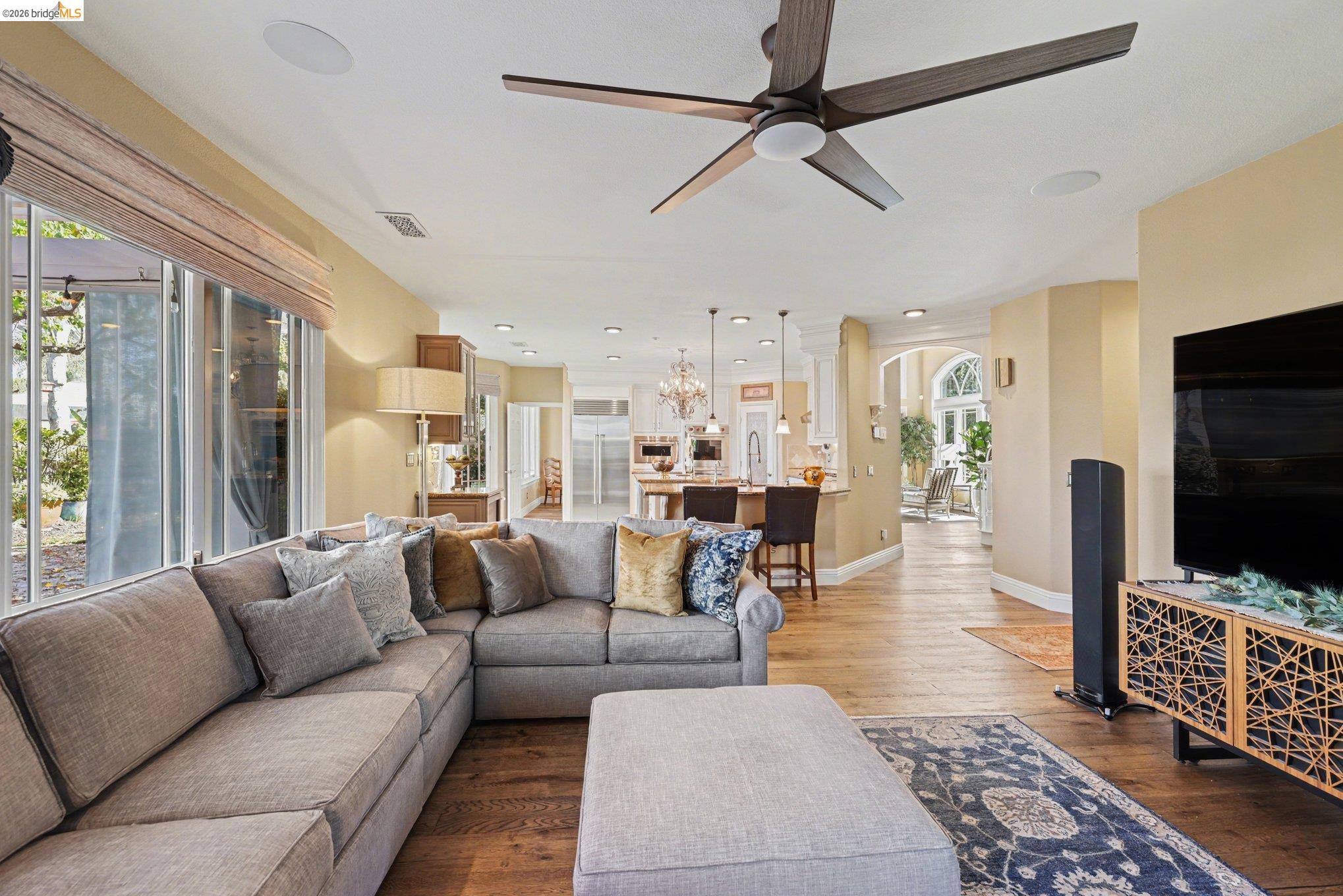 550 Rutherford Circle Brentwood, CA 94513 - Photo 10 of 28 Living room featuring light wood finished floors, a ceiling fan, arched walkways, and suspended lighting