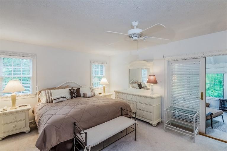 17 Meadowbrook Road Mashpee, MA 02649 - Photo 9 of 29 a bedroom with a bed and a chandelier