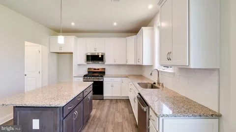 a kitchen with granite countertop a stove sink and cabinets