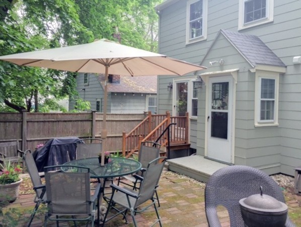 62 Edgehill Road Winthrop, MA 02152 - Photo 24 of 29 a patio with a table and chairs under an umbrella