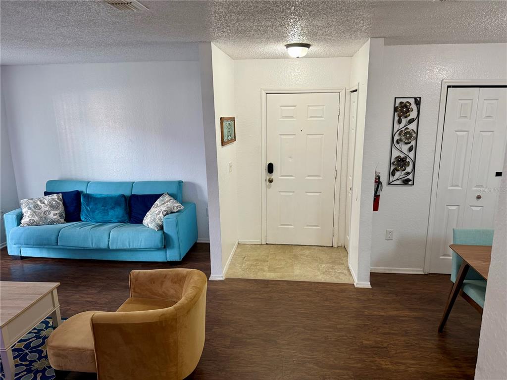 3705 Southwest 27th Street, Unit 1112 Gainesville, FL 32608 - Photo 5 of 23 a living room with furniture and a wooden floor
