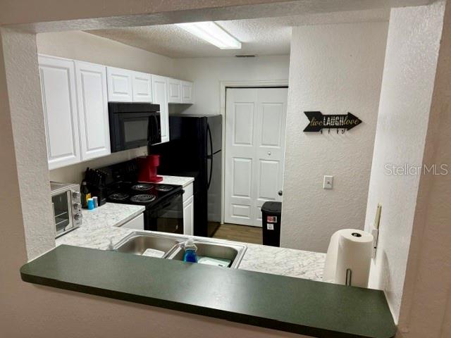 3705 Southwest 27th Street, Unit 1112 Gainesville, FL 32608 - Photo 6 of 23 a kitchen with a sink a stove and refrigerator
