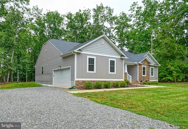 a front view of a house with a yard and trees