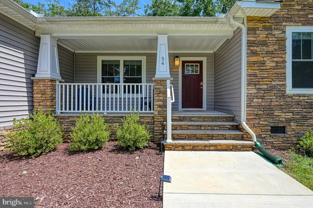 a view of a house with a small yard and wooden floor and fence