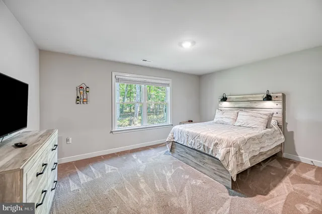 a bedroom with a bed dresser and a window