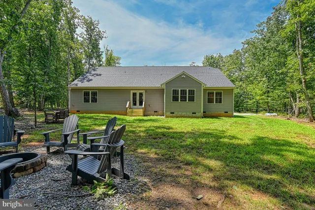 a view of a house with a yard chairs and a patio