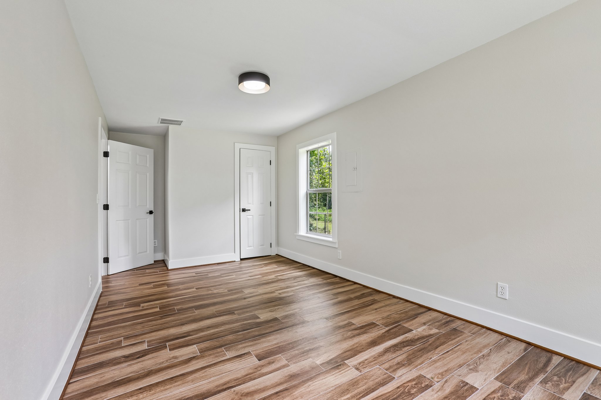 2089 Farm To Market Road 1704 Elgin, TX 78621 - Photo 16 of 31 Natural wood-look tile flooring flows throughout this well-lit, vacant room, awaiting your personal touch.