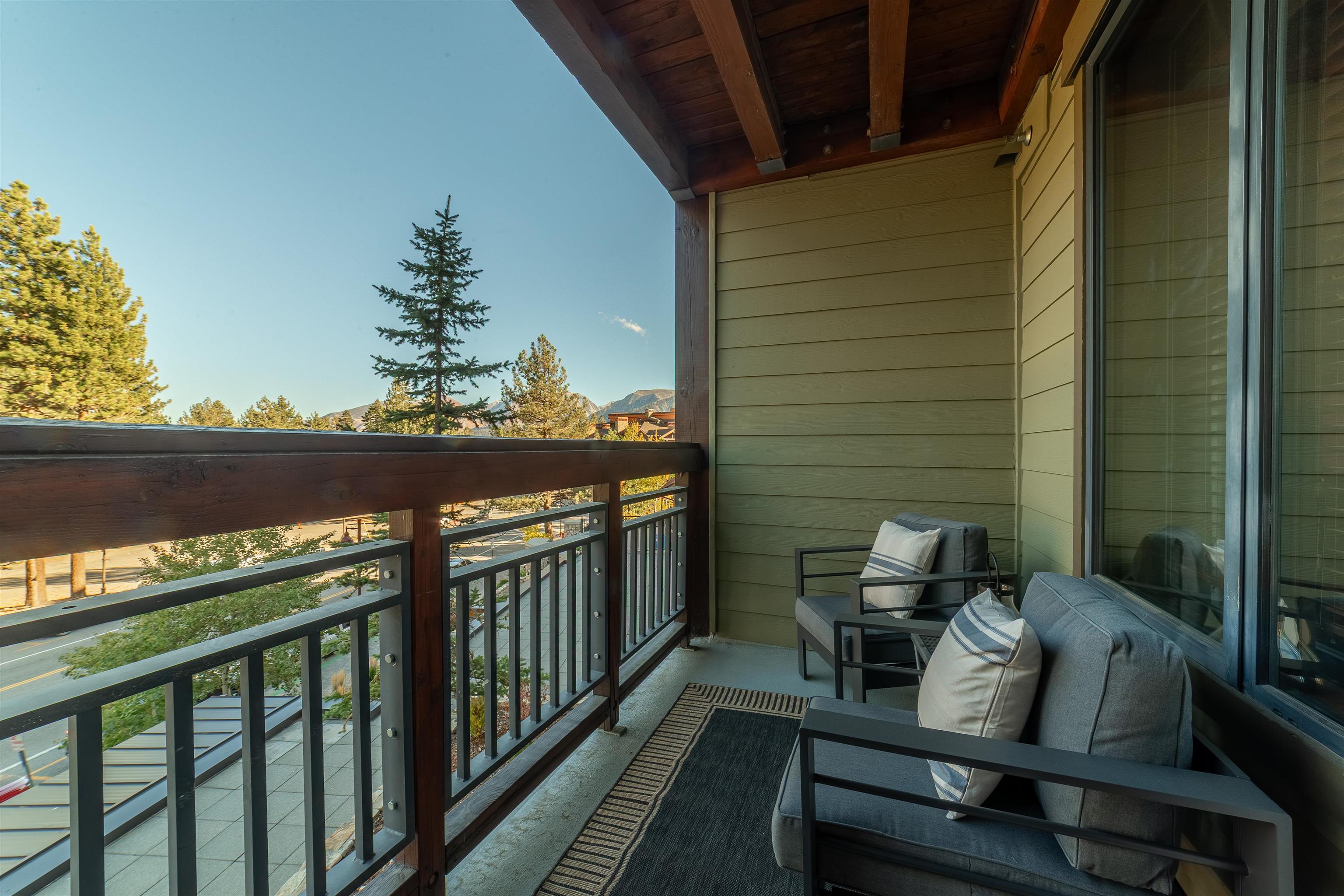 6201 Minaret Road, Unit 2221 Mammoth Lakes, CA 93546 - Photo 27 of 44 Private balcony featuring a wood-beam ceiling, siding exterior, metal and wood railing, and concrete flooring
